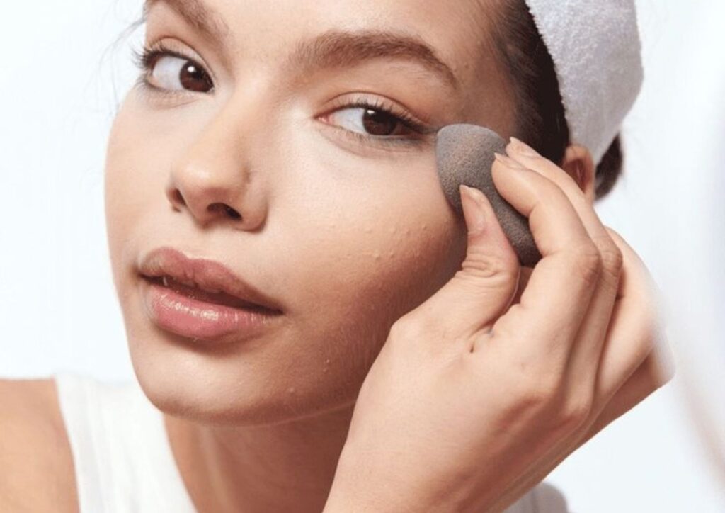 Using a damp makeup sponge to fix cakey foundation and soften makeup