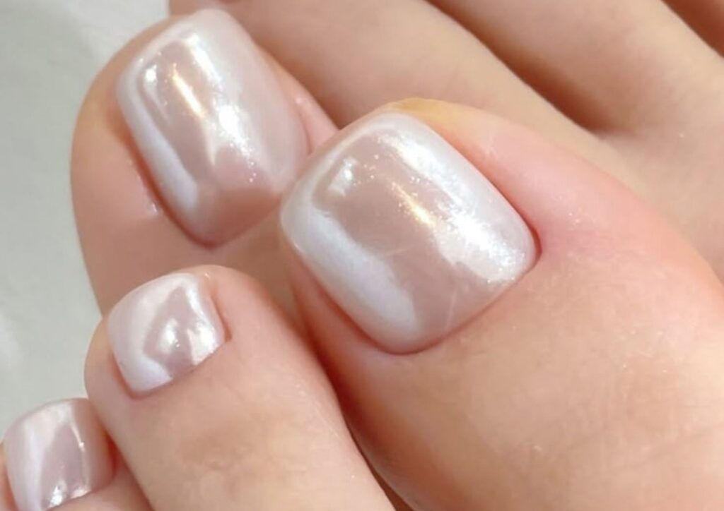 Wedding toenail ideas with pearl chrome and a milky glossy finish